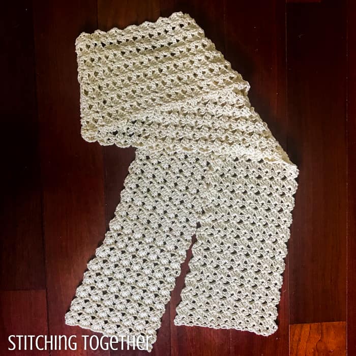 shell stitch crochet scarf laid out and partially folded