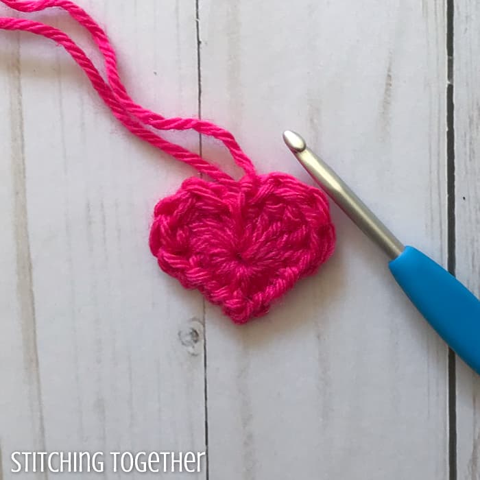tiny crochet heart with yarn ends still visible