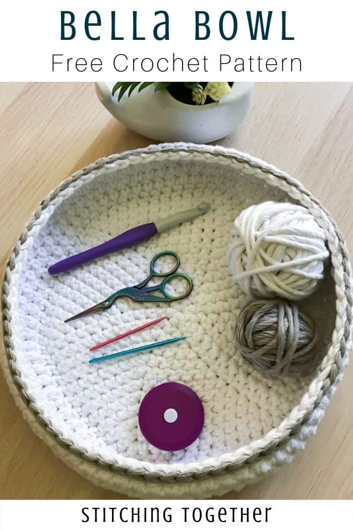 white and gray crochet bowl filled with yarn and crochet tools