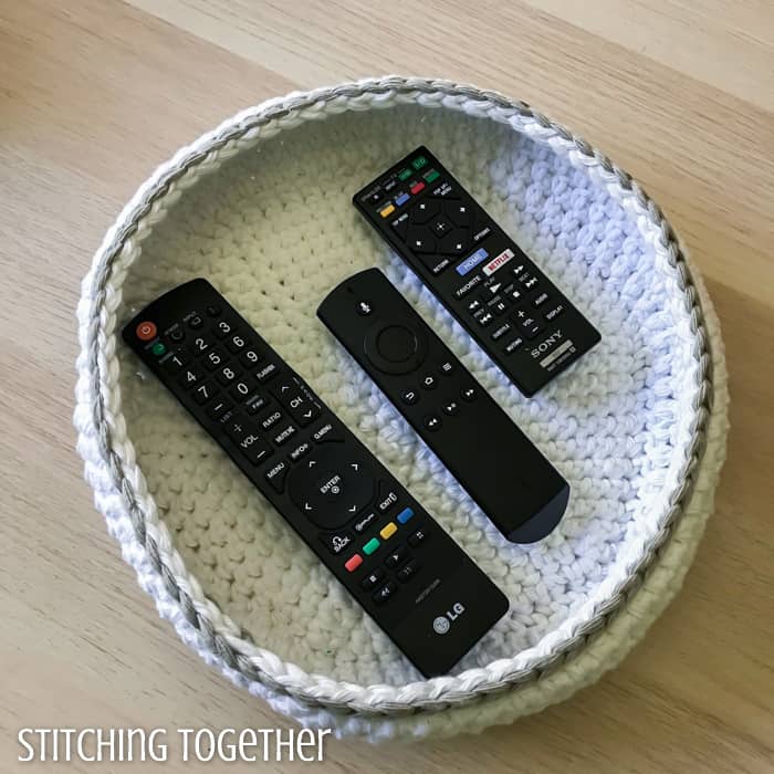 tv remotes held in a crochet bowl