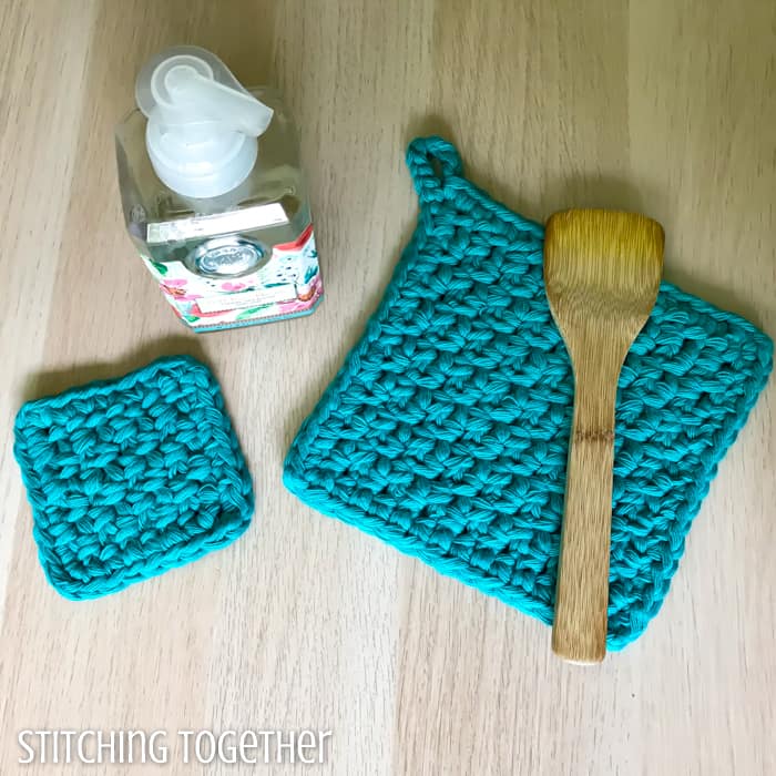2 potholders crocheted, a wooden spoon and bottle of soap