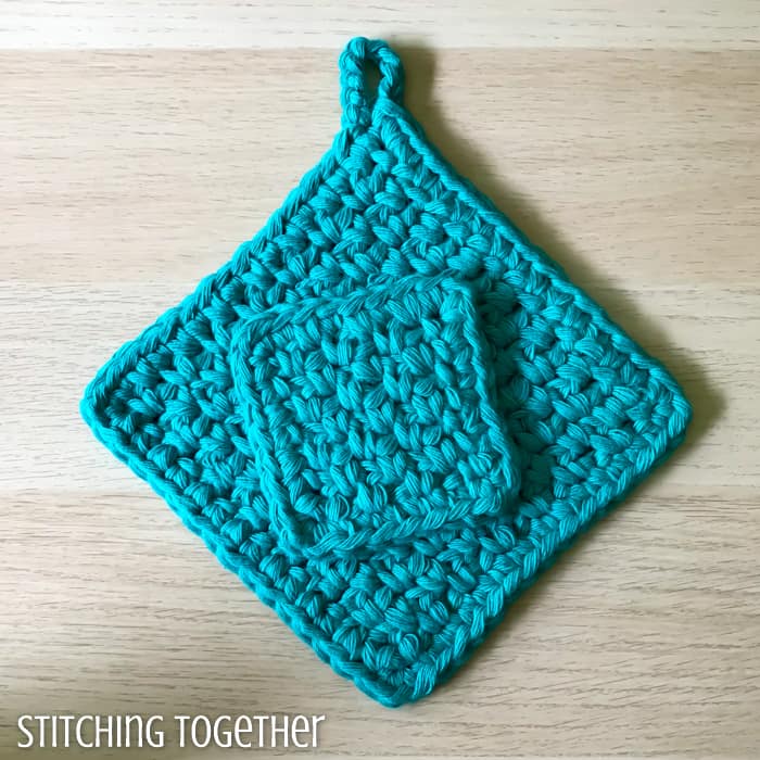 small crochet cloth sitting on top of a large crochet potholder
