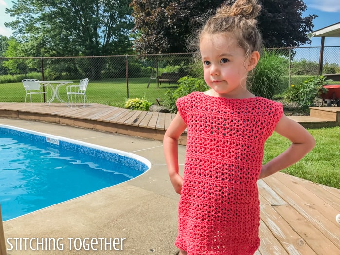 child modeling a coral crochet dress for a girl