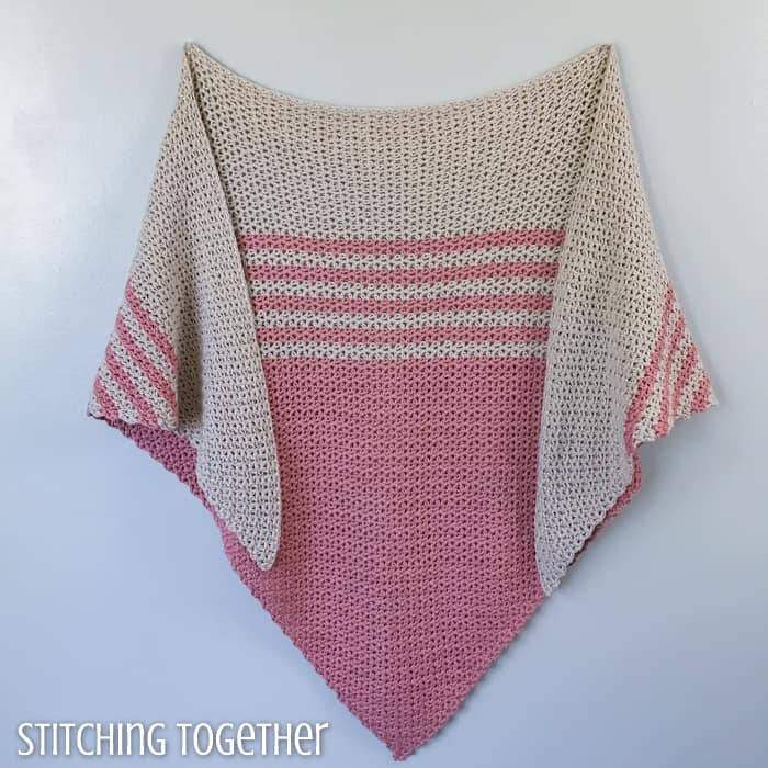 pink and tan striped crochet triangle shawl hanging