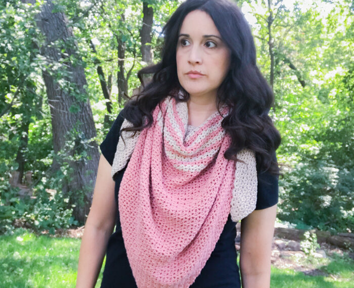 woman wearing a pink and tan striped crochet triangle scarf