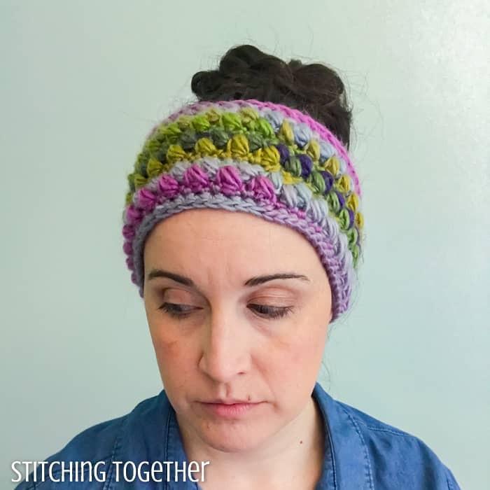 lady wearing a colorful crochet ear warmer with puff stitches