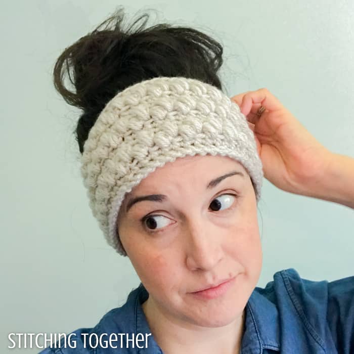 lady wearing a neutral puffy crocheted ear warmer