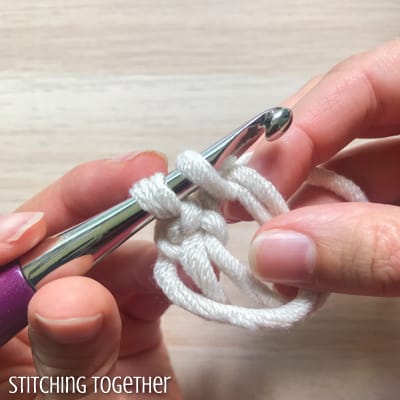 white yarn and purple crochet hook