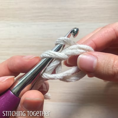 white yarn and purple crochet hook