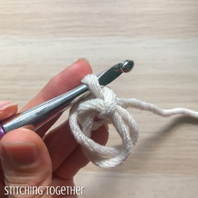 white yarn and purple crochet hook