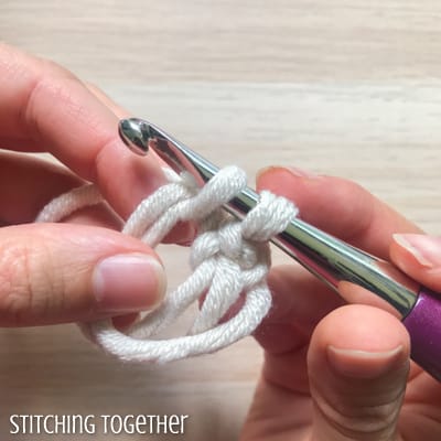 white yarn and purple crochet hook