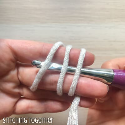 Hook and yarn wrapped around fingers