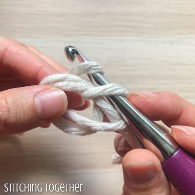 white yarn and purple crochet hook