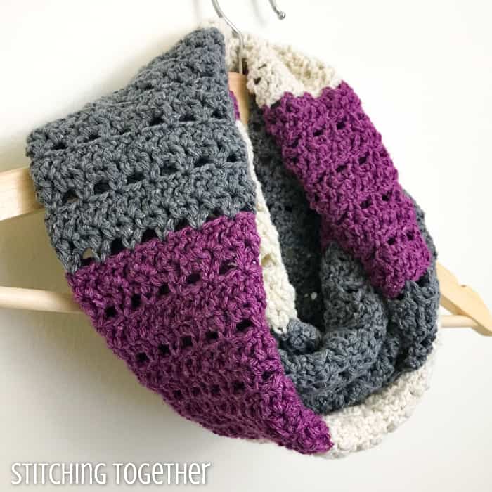 striped crochet infinity scarf draped on a hanger