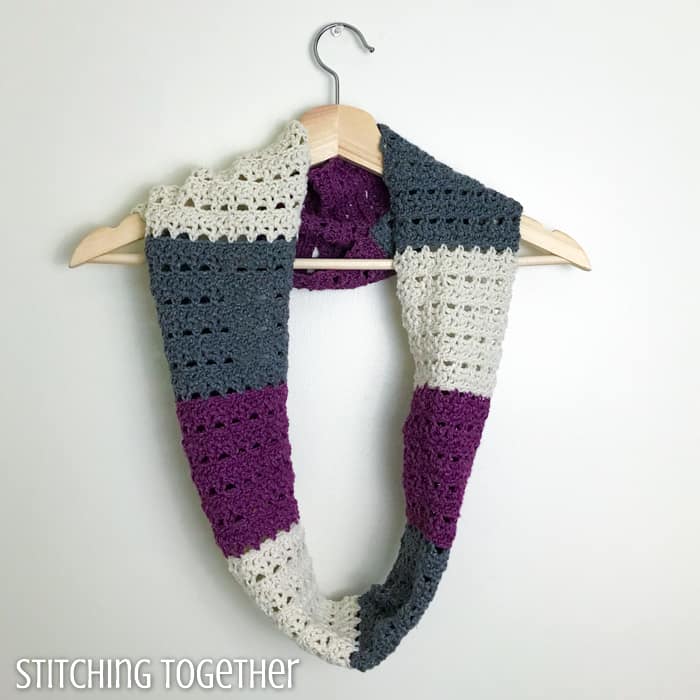 crochet infinity scarf hanging on a hanger