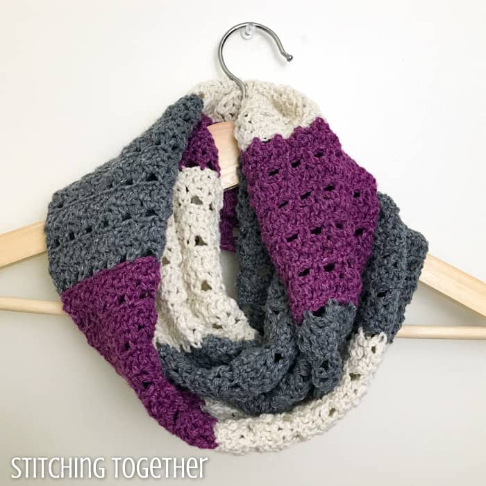 infinity scarf with stripes looped on a hanger