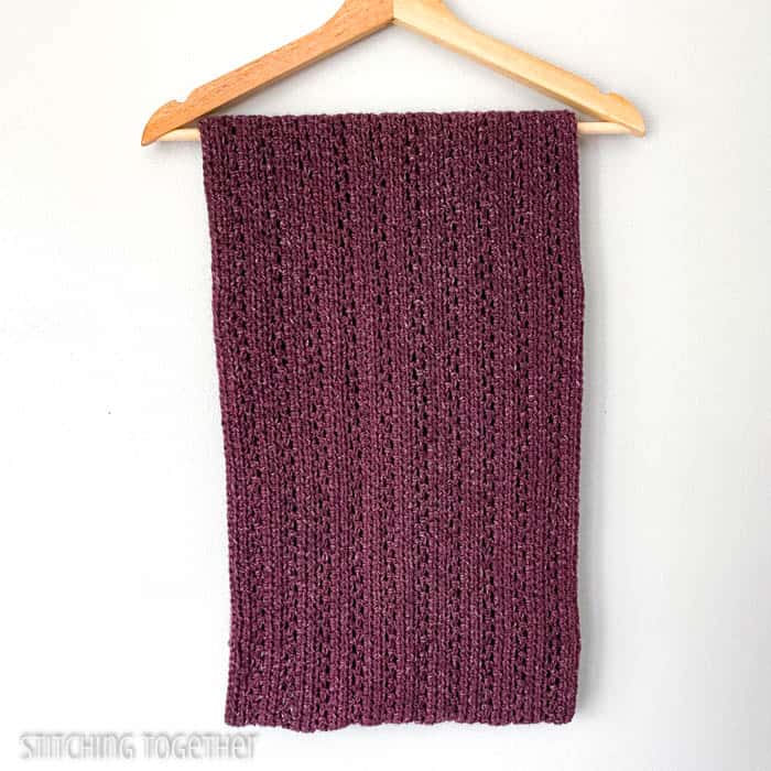 large burgundy infinity scarf folded and draped on a hanger