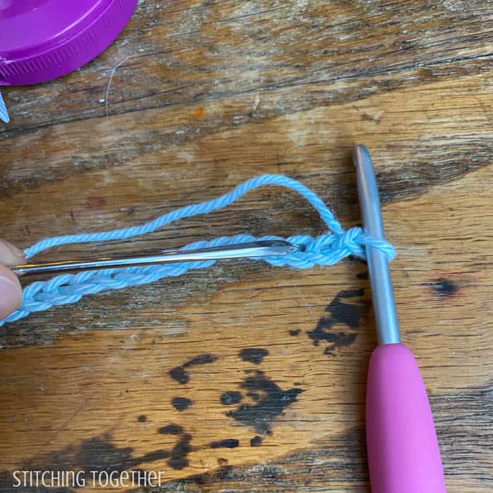 crochet chain on a hook with a needle pointing to the top loop