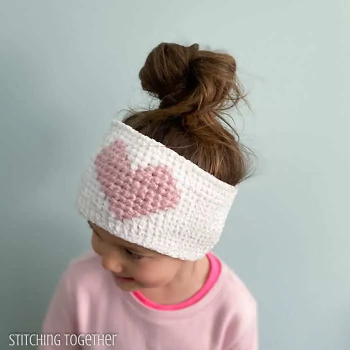 girl wearing a crochet heart ear warmer