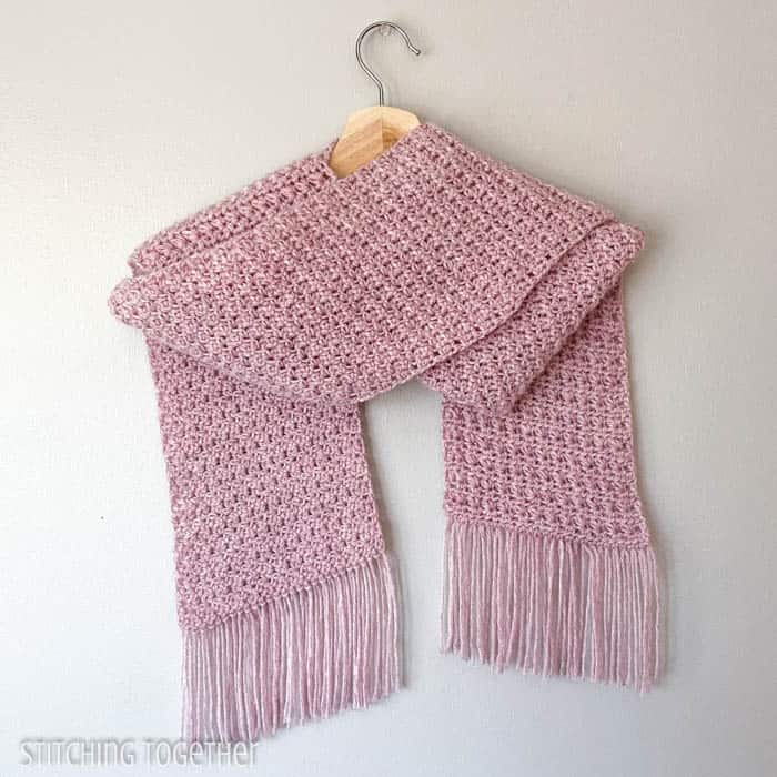 pink crochet scarf with fringe hanging