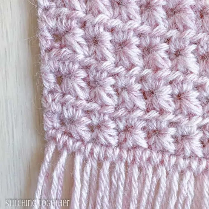close up of star like crochet stitches in pink yarn