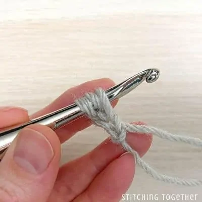 crochet hook with yarn showing steps in a stitch