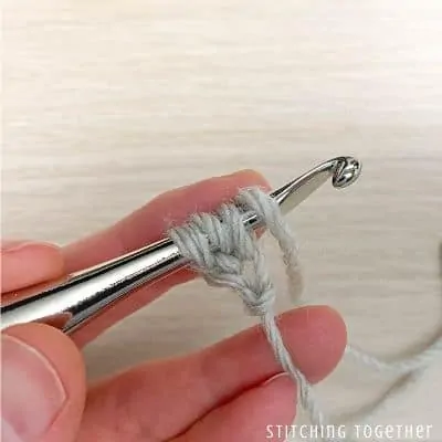 crochet hook with yarn showing steps in a stitch