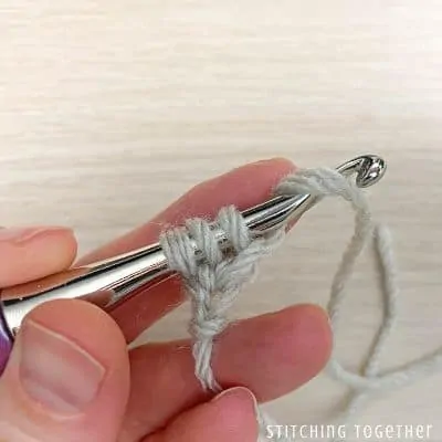 crochet hook with yarn showing steps in a stitch