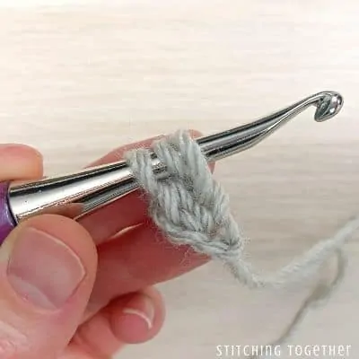 crochet hook with yarn showing steps in a stitch