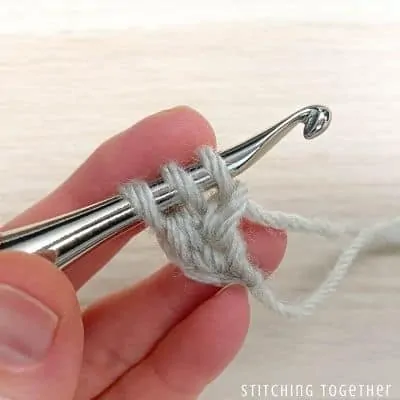 crochet hook with yarn showing steps in a stitch