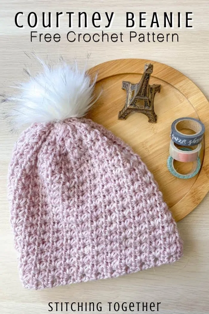 pink crochet beanie with white pom pom laying flat