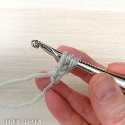 crochet hook with yarn showing steps in a stitch