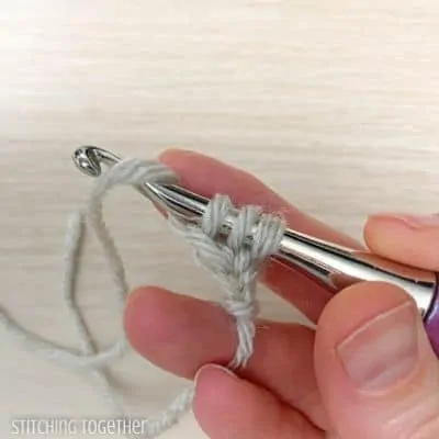 crochet hook with yarn showing steps in a stitch