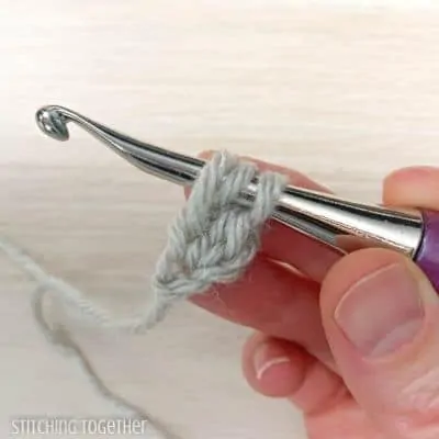 crochet hook with yarn showing steps in a stitch