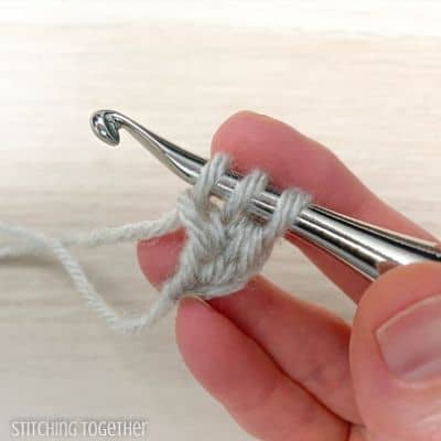 crochet hook with yarn showing steps in a stitch