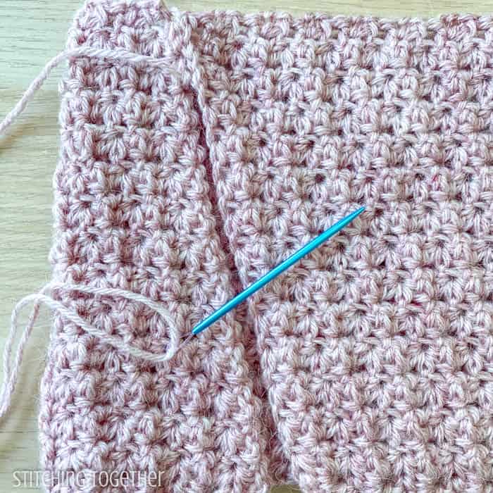 crochet fabric being sewn together with a yarn needle