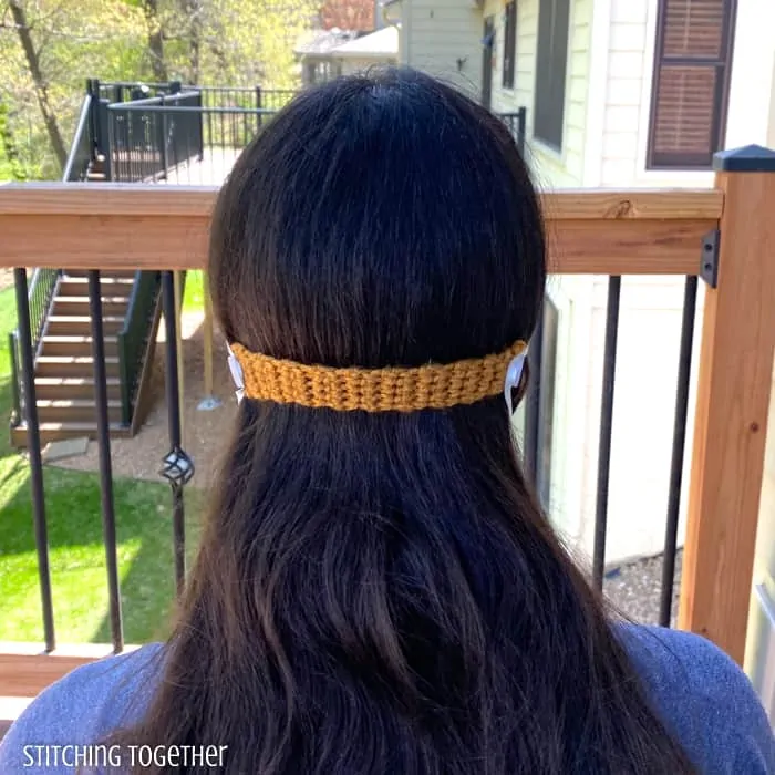 back of head view of lady wearing crochet ear saver for mask