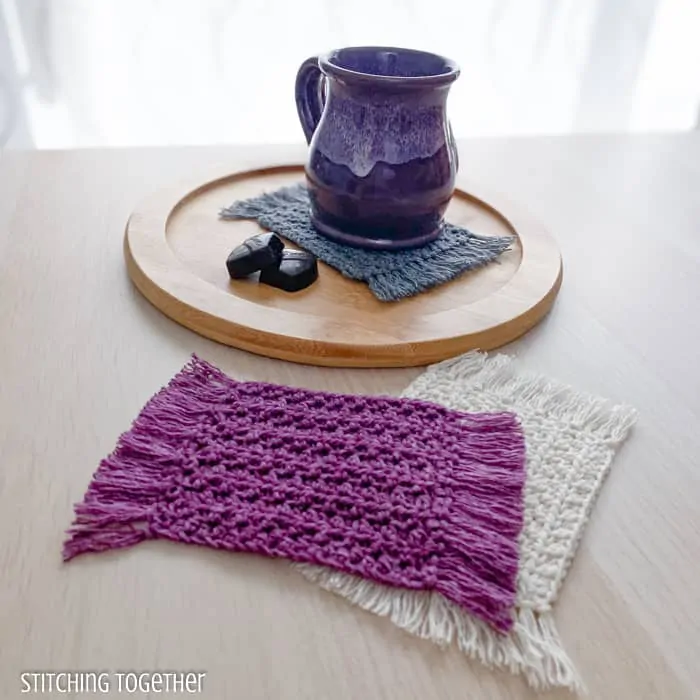 mug sitting on a crochet coaster with 2 other coasters stack in front