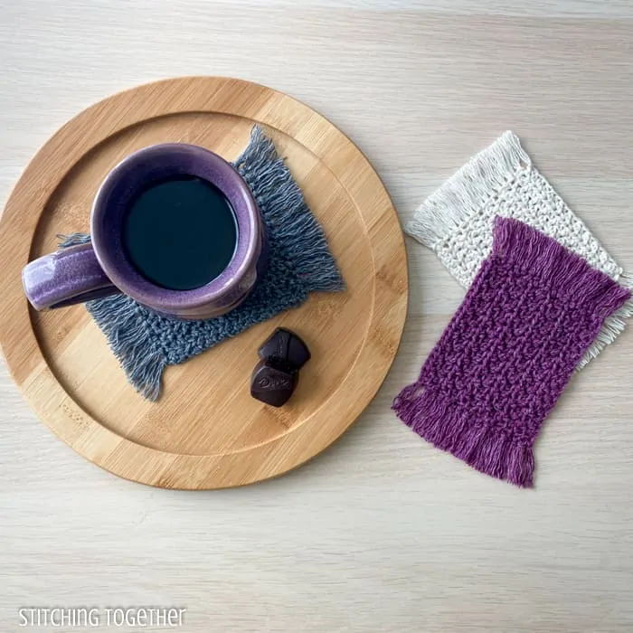 mug sitting on a crochet coaster with 2 other coasters stacked near the mug