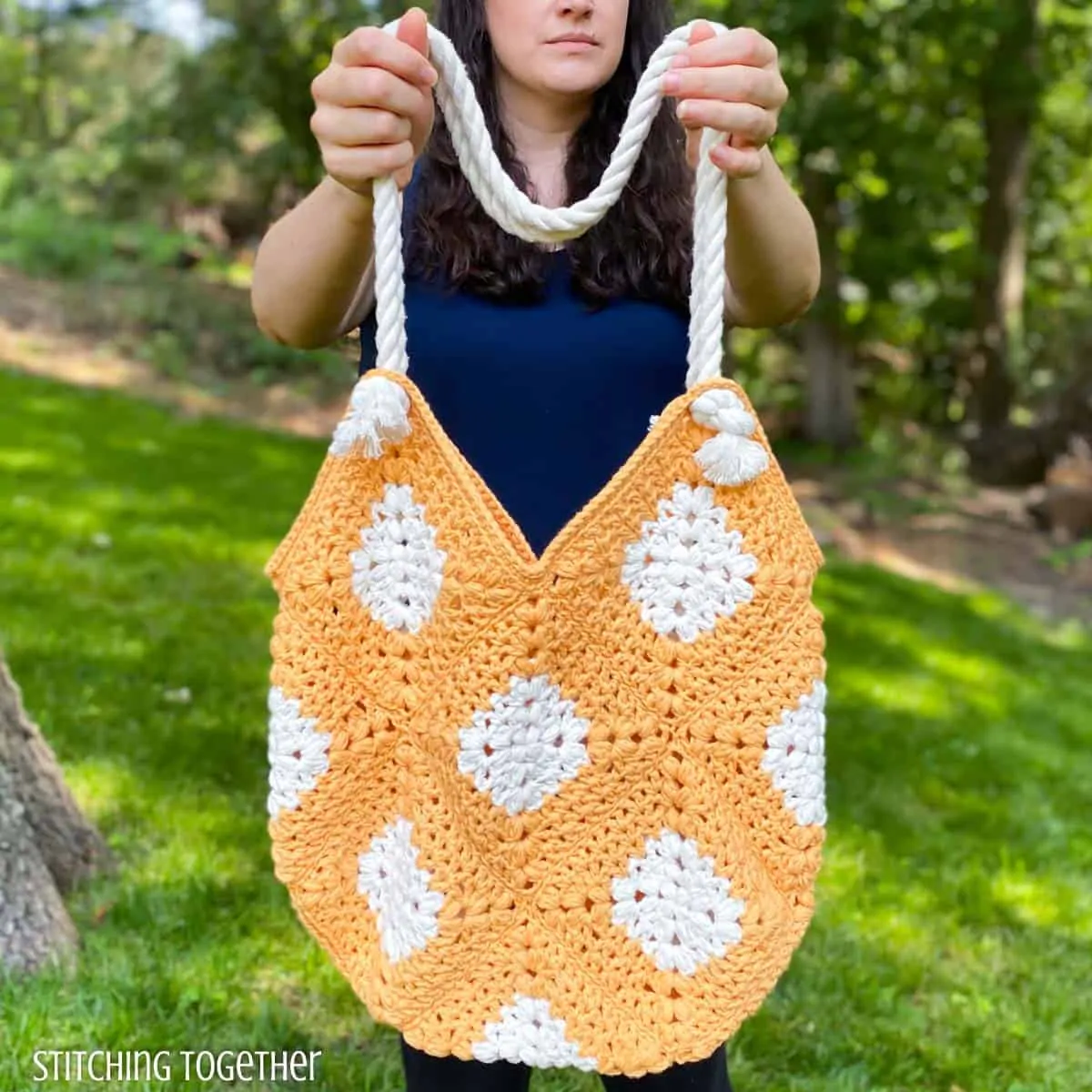 lady holding orange and white crochet market bag