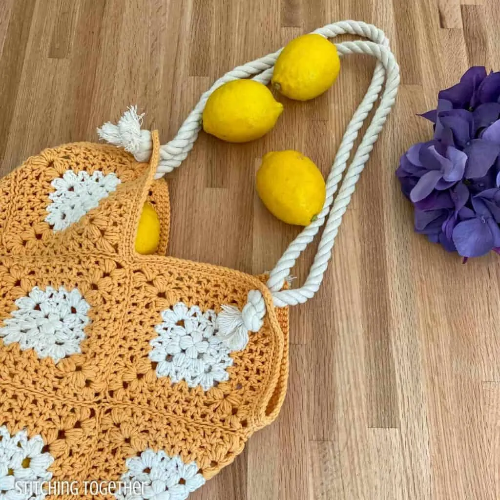 crochet market tote on a counter with lemons and flowers