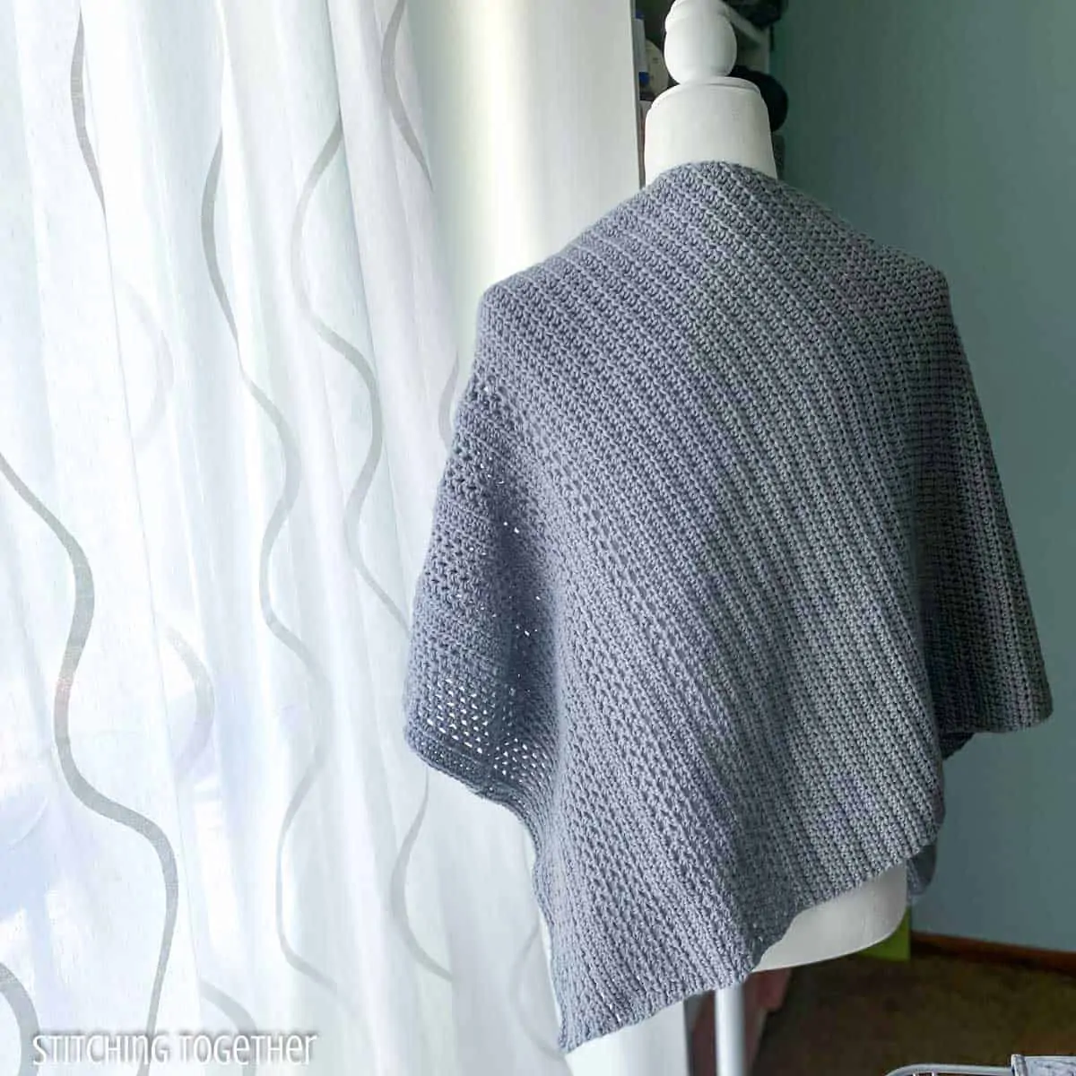 crochet shawl on a mannequin facing away