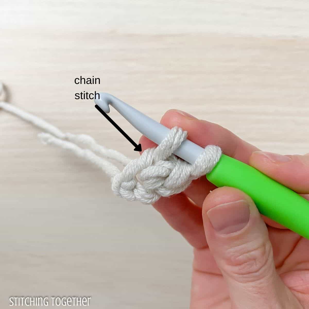hand, yarn, and hook showing how to chainless foundation