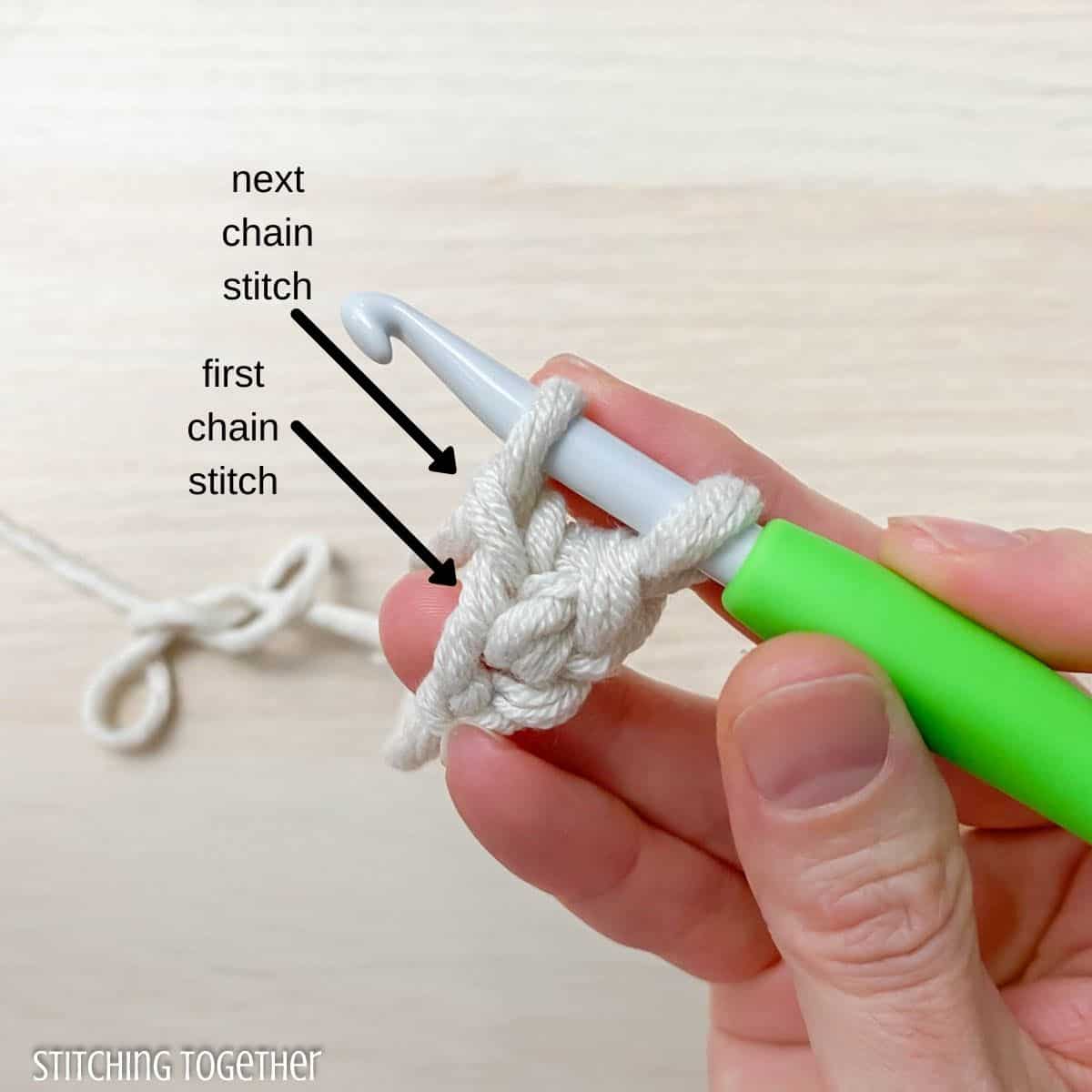 hand, yarn, and hook showing how to single crochet foundation stitch