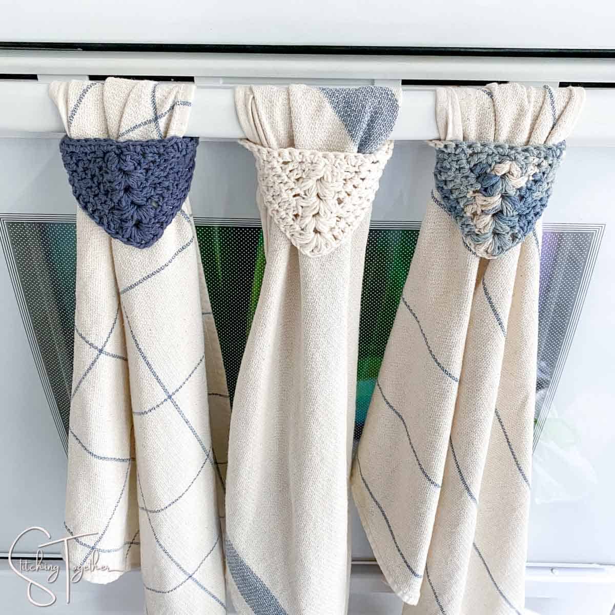 3 dishtowels hanging on an oven by crochet towel hangers