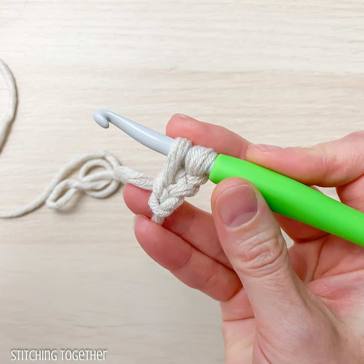 crochet hook, yarn. and hand showing steps to fsc