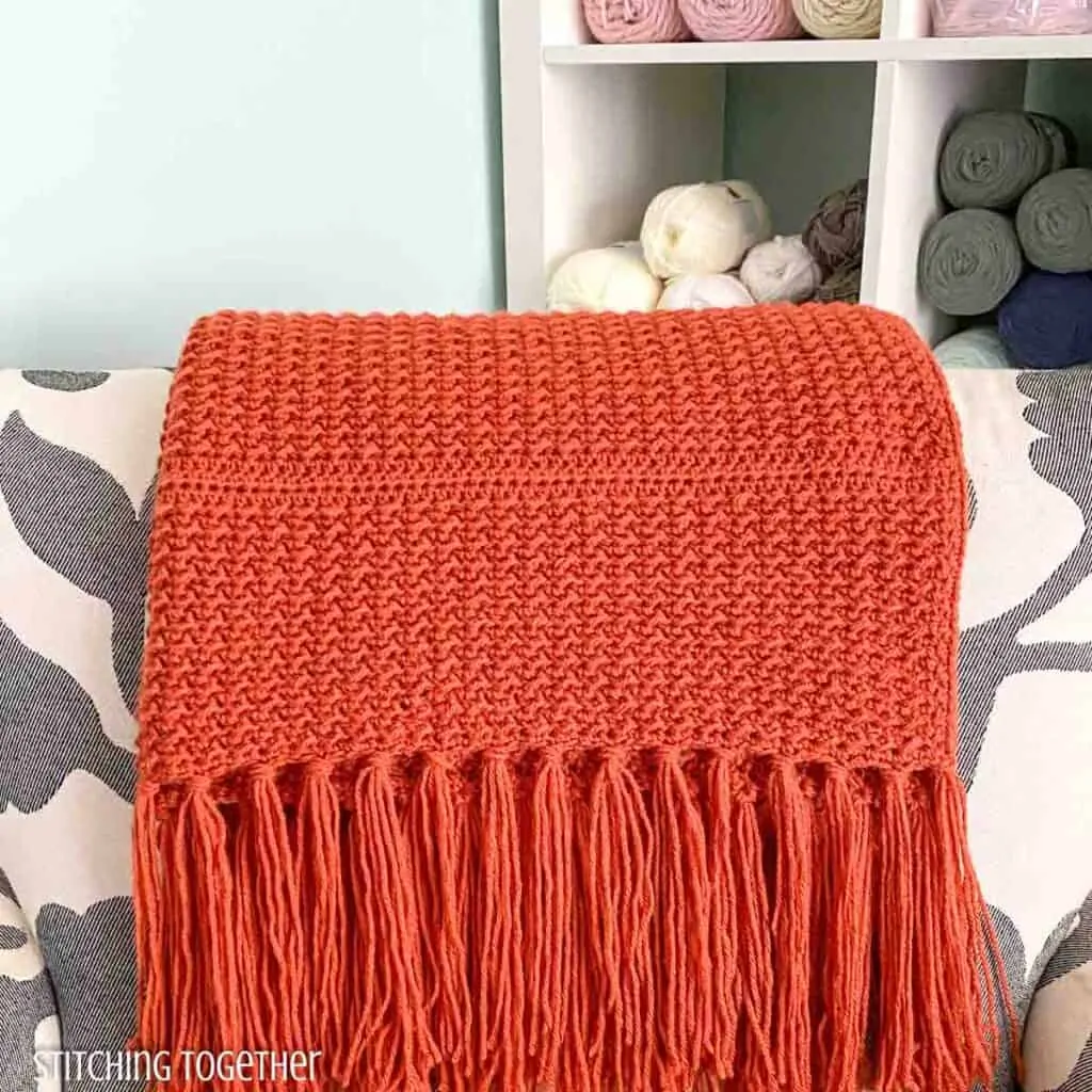 crochet lap blanket draped on the back of a chair