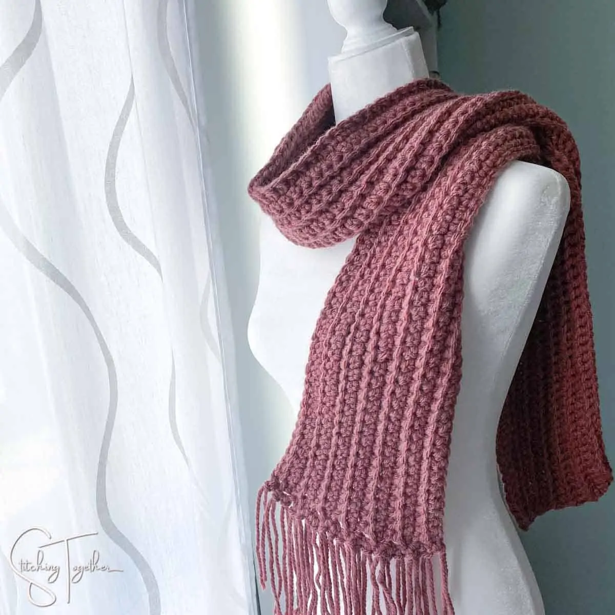 purple bulky crochet scarf on a mannequin