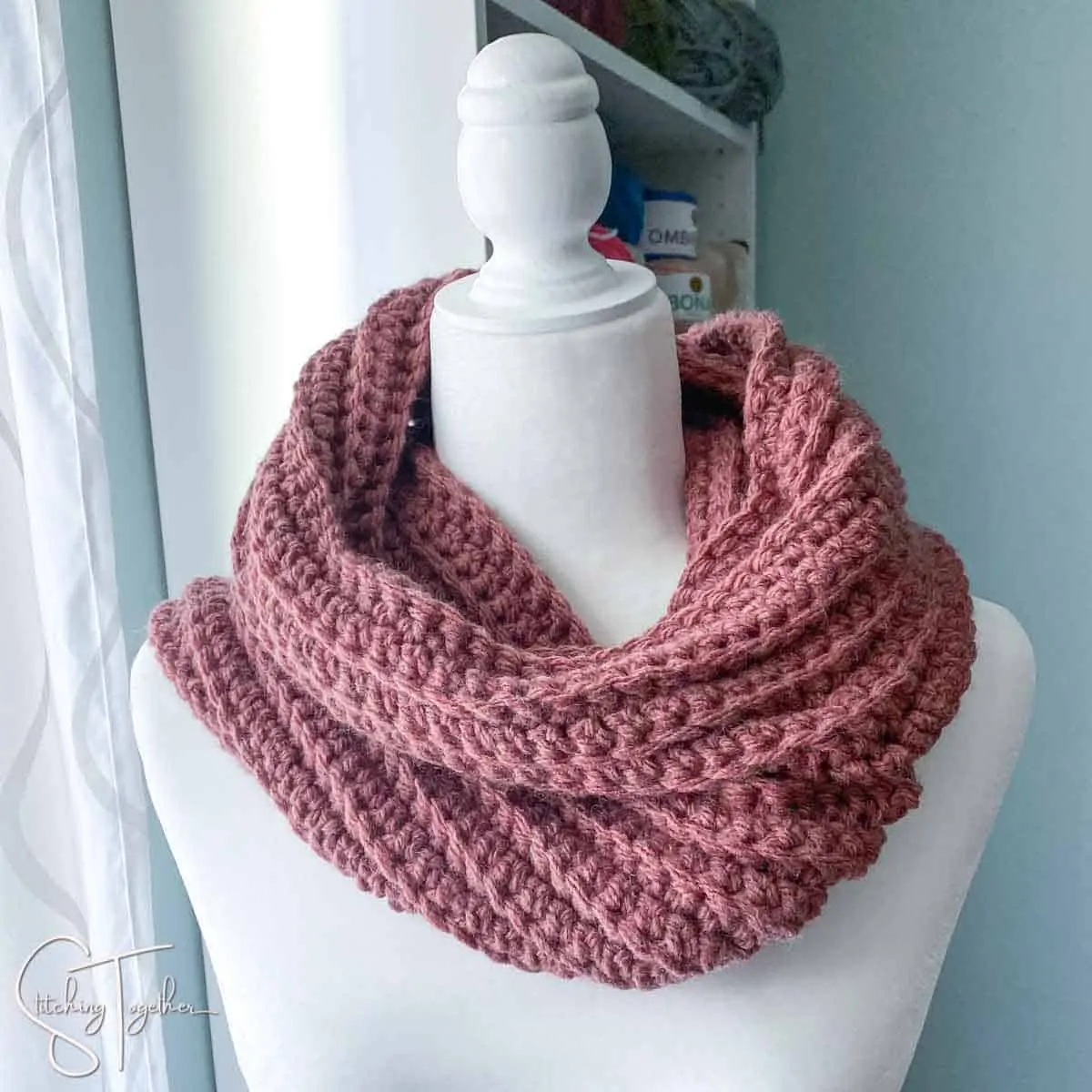 purple wrapped crochet scarf on a mannequin
