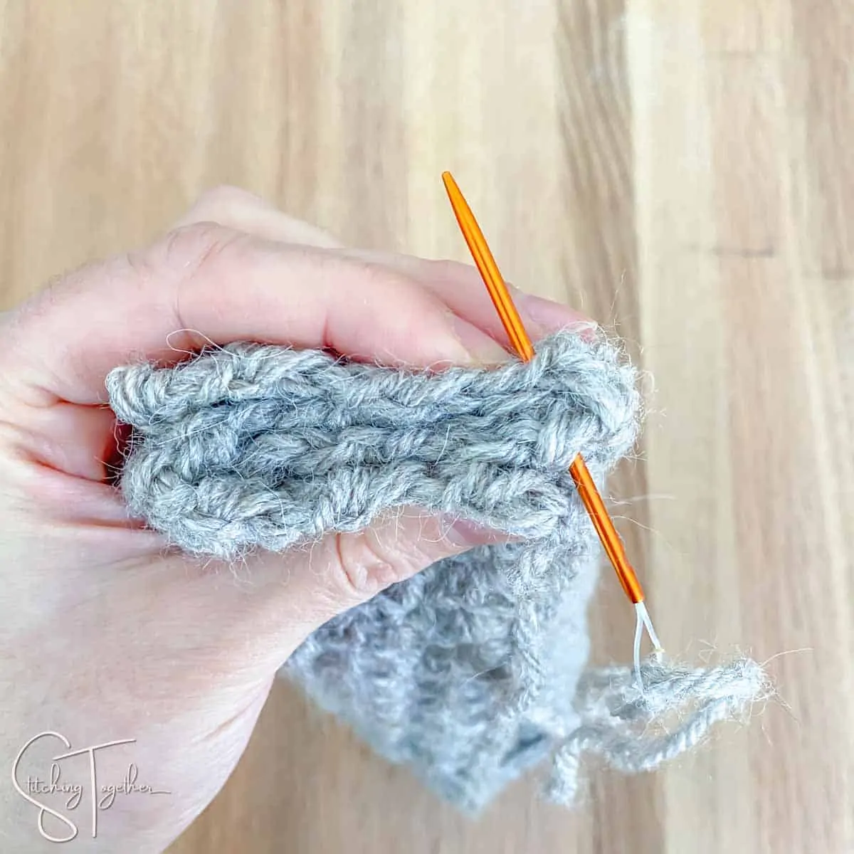 a crochet rectangle being sewn together to make a headband